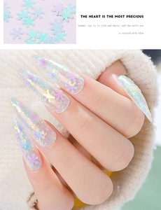 Macro view of holographic snowflake nail glitters on long stiletto manicure with laser effect