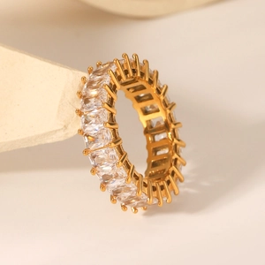 Close-up of gold-plated eternity ring with rectangular white zircons on stone display