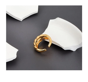 Detailed macro shot of gold croissant ring with twisted texture on minimalist background