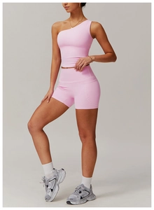 Détail d'un haut de sport rose à une épaule et d'un short taille haute à coutures décoratives