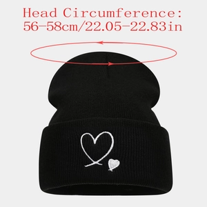 Detail of heart embroidery on a black knit beanie with head size measurements