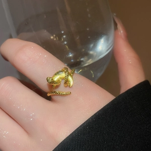 Close-up of golden snake ring with scale texture and shimmering cat-eye stone detail