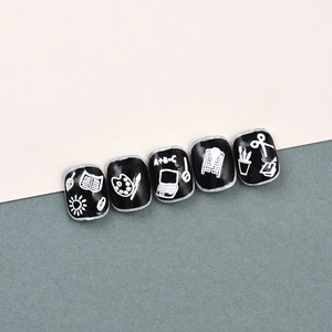 Close-up of 5D black nail stickers with white hand-drawn school and creative art icons