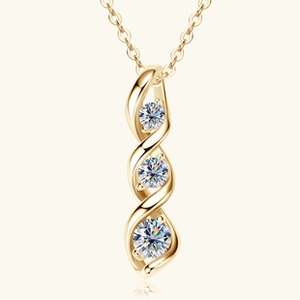 Close-up of golden spiral pendant with three vertical round sparkling gemstones