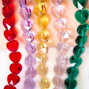 Macro view of multi-faceted heart-shaped crystal glass beads in five vibrant colors