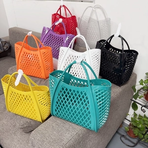 Stack of colorful hollow-out silicone tote bags in various vibrant shades on a sofa