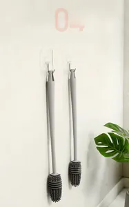 Silicone cup brush with long handle hanging on a hook for storage and drainage