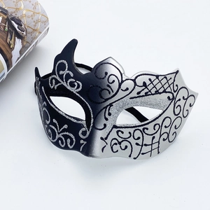 Detail of black and silver masquerade mask with glitter swirls and lace patterns