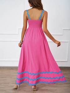 Detail of the pink summer maxi dress showing elastic smocked back and blue wavy trim