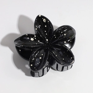 Detailed top view of a black lily hair claw clip with silver laser splatter finish
