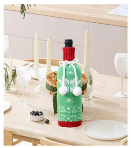 Knitted Christmas wine bottle cover with festive red and green snowflake patterns