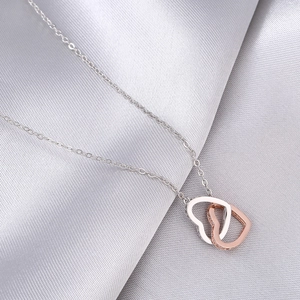 Mother daughter rose gold and silver interlocking heart necklace on silk background