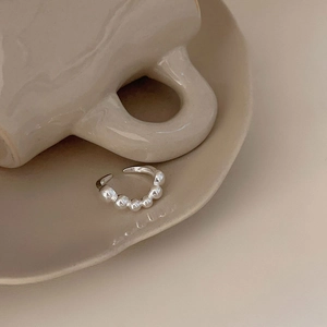 Minimalist S925 sterling silver beaded open ring displayed on beige ceramic decor