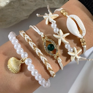 Set de pulseras bohemias con conchas marinas, perlas blancas y dijes de estrella