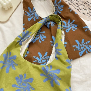 Close-up of blue floral print canvas tote bags in green and brown with white lining