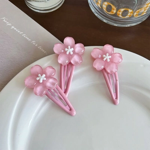 Three sweet pink cherry blossom hair clips in a ceramic bowl for women and girls