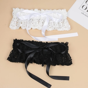 Detailed view of elegant wide lace waistband with decorative satin bow in black and white