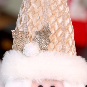 Detail of champagne gold waffle fabric with faux fur trim and gold holly leaf ornament