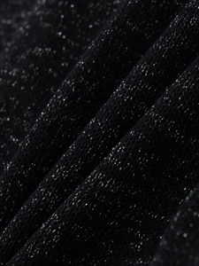 Macro di tessuto a maglia nera con fili metallici argento scintillanti e pieghe materiche