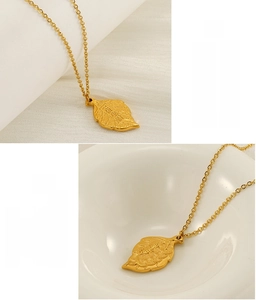 Macro detail of leaf pendant necklace with gold plating and lucky pattern engraving