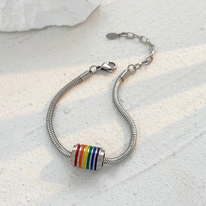 Detail of silver snake chain bracelet with rainbow enamel cylinder pendant and lobster clasp