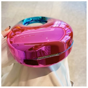 Detail of pink acrylic handbag featuring a glossy metallic finish and blue handle