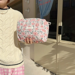 Detailed macro view of quilted floral makeup bag featuring elegant flower patterns