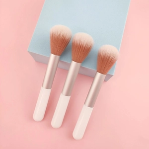 Three portable white and rose gold blush brushes with soft gradient fiber bristles