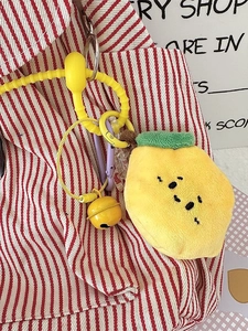 Porte-clés citron en peluche avec clochette jaune et mousqueton violet sur sac