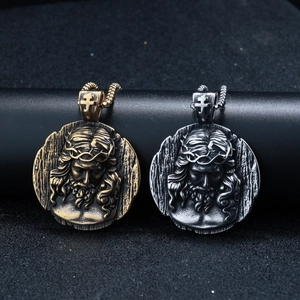 Close-up of gold and silver Jesus pendant necklaces with vintage relief details