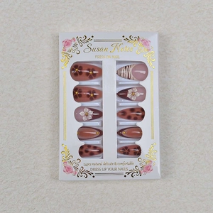 Almond press-on nails set with brown floral patterns, leopard prints and pearl accents
