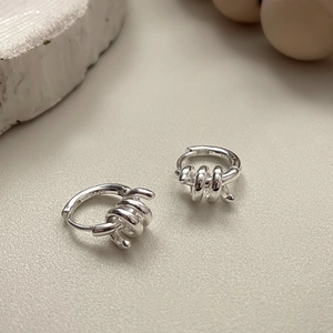 Dettaglio ravvicinato di orecchini a cerchio in argento S925 con design a spirale