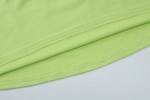 Gros plan détaillé de l'ourlet à double couture de la robe en maille vert clair