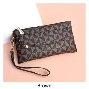 Detail of coffee brown textured plaid handbag with golden zipper and leather wrist strap