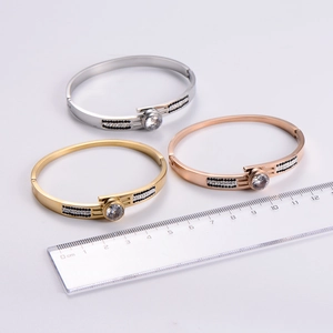 Three-piece bangle set in gold, rose gold, and silver with large zircon and side crystals