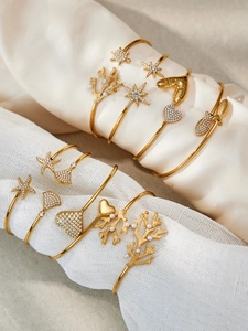 Détail de joncs en acier inoxydable plaqué or 18k avec breloques étoile de mer et corail
