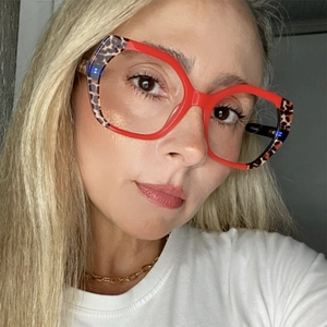Detailed view of red polygon TR90 eyeglass frames with leopard print temples on a face