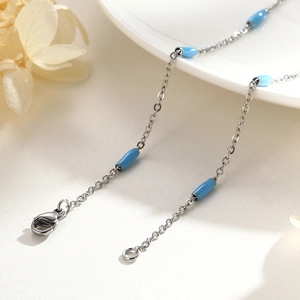 Minimalist gold-plated titanium steel necklace with elegant blue cylindrical beads on white tray