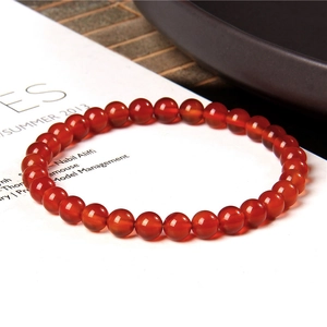 Detailed macro shot of 6mm red agate gemstone beads on a premium elastic bracelet
