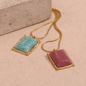 Detail view of rectangular natural stone pendants with vintage 18K gold plated borders