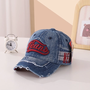Détail de la casquette baseball en denim bleu avec bord usé et broderie Jeans