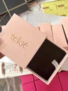 Close-up of pink drawer-style jewelry gift box with gold logo and white pull handle