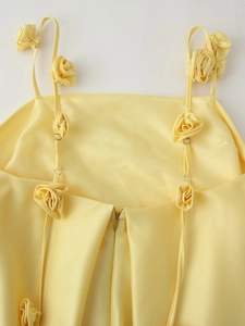 Detail of satin slip dress featuring 3D rose flower straps and hidden back zipper
