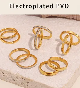 Vue macro de bagues minimalistes dorées PVD avec diamants pavés sur texture pierre