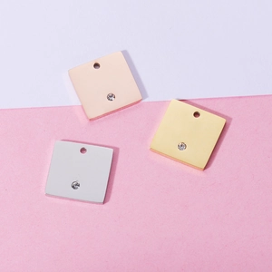 Three square stainless steel pendants in rose gold, gold, and silver with inlaid diamond