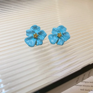 Detail view of flower studs with blue marble petals and a yellow crystal center