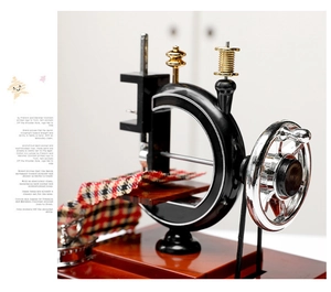Close-up of vintage sewing machine music box with metal handwheel and plaid fabric detail