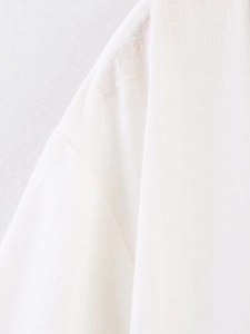 Close-up of breathable white linen fabric texture and stitching on elegant top