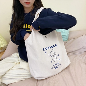 Détail du sac fourre-tout en toile avec motif chiot bleu et fermeture par bouton pression