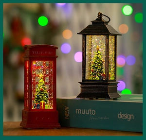 Close-up of lighted Christmas snow globe telephone booth and lantern with sparkling glitter